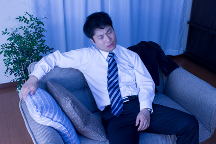 ソファーに腰をかける疲れたビジネスマン